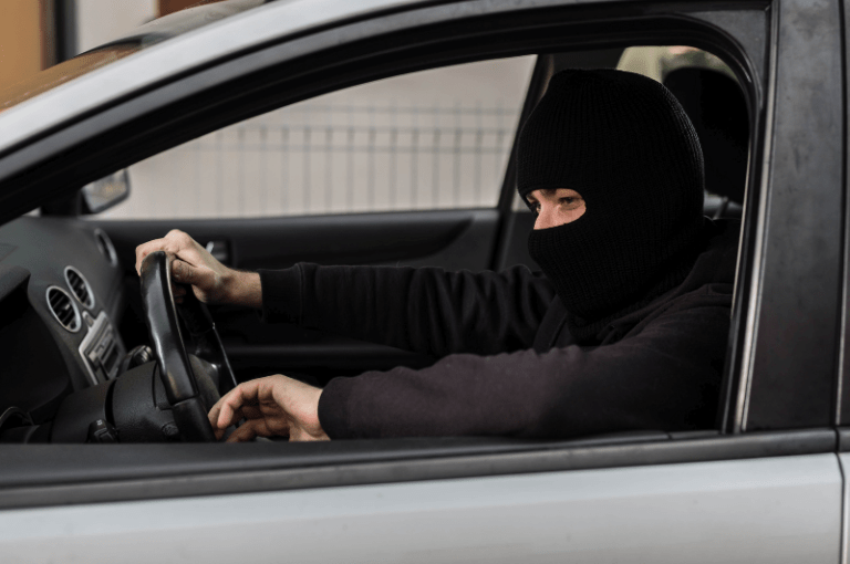 Criminal sits in car that they are stealing using fake driver's license at car dealership